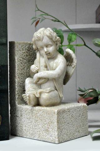 urocza podpórka do książek z muzykującym aniołkiem